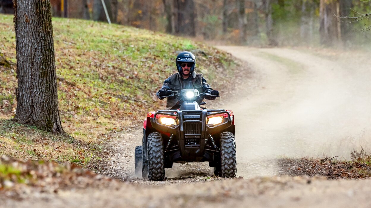 A rider on a Honda Rubicon kicking up dust. 
