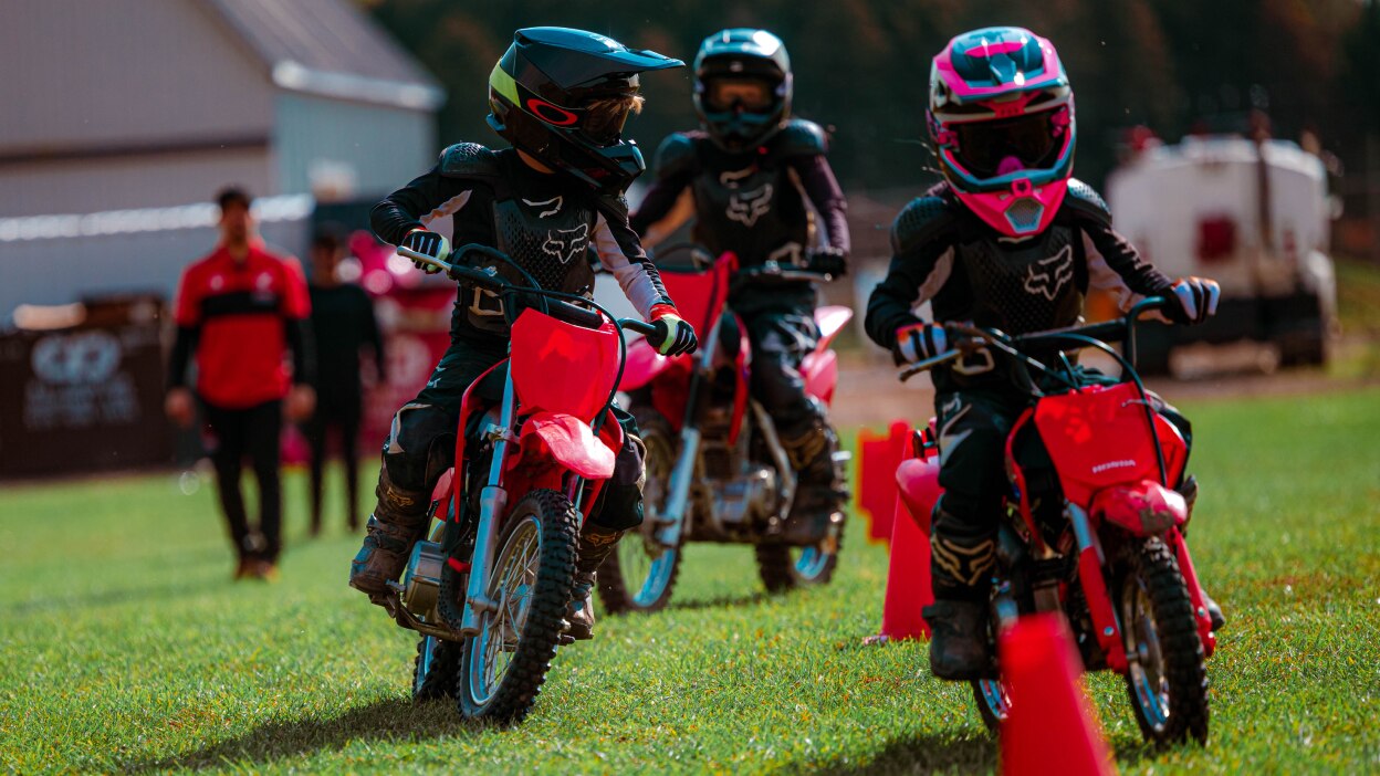 Three Junior Red Riders snaking through pylons 