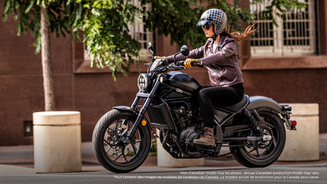 Rider going left on road. Building, pillar and tree in background. Non-Canadian model(s) may be shown.  Actual Canadian production model(s) may vary.