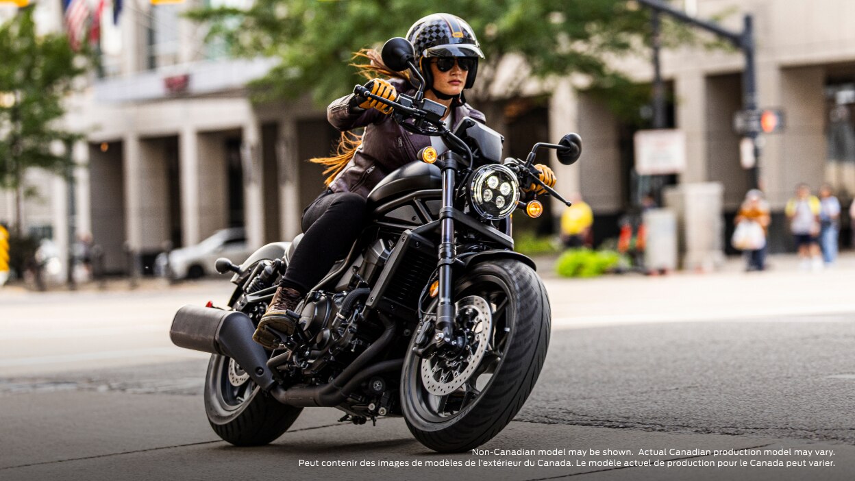 Rider turning left in road. Building and trees in background. Non-Canadian model(s) may be shown.  Actual Canadian production model(s) may vary.