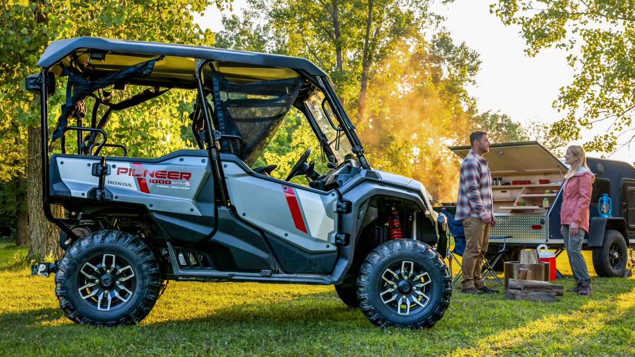 Pioneer on grass. People in background with BBQ.